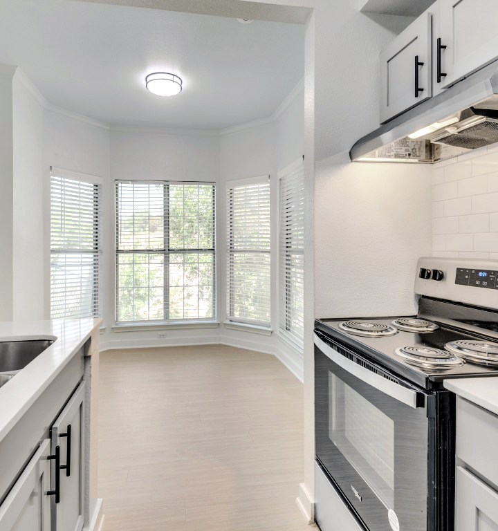 a kitchen with white cabinets and stainless steel appliances at The Stetson