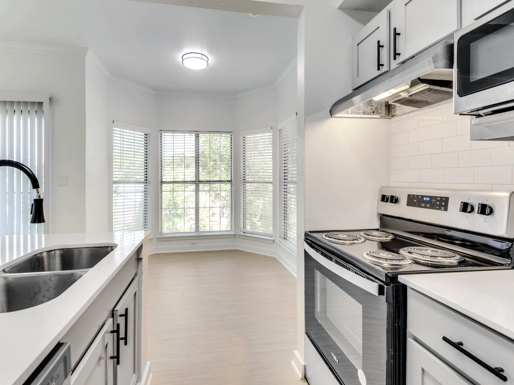 a kitchen with white cabinets and stainless steel appliances at The Stetson