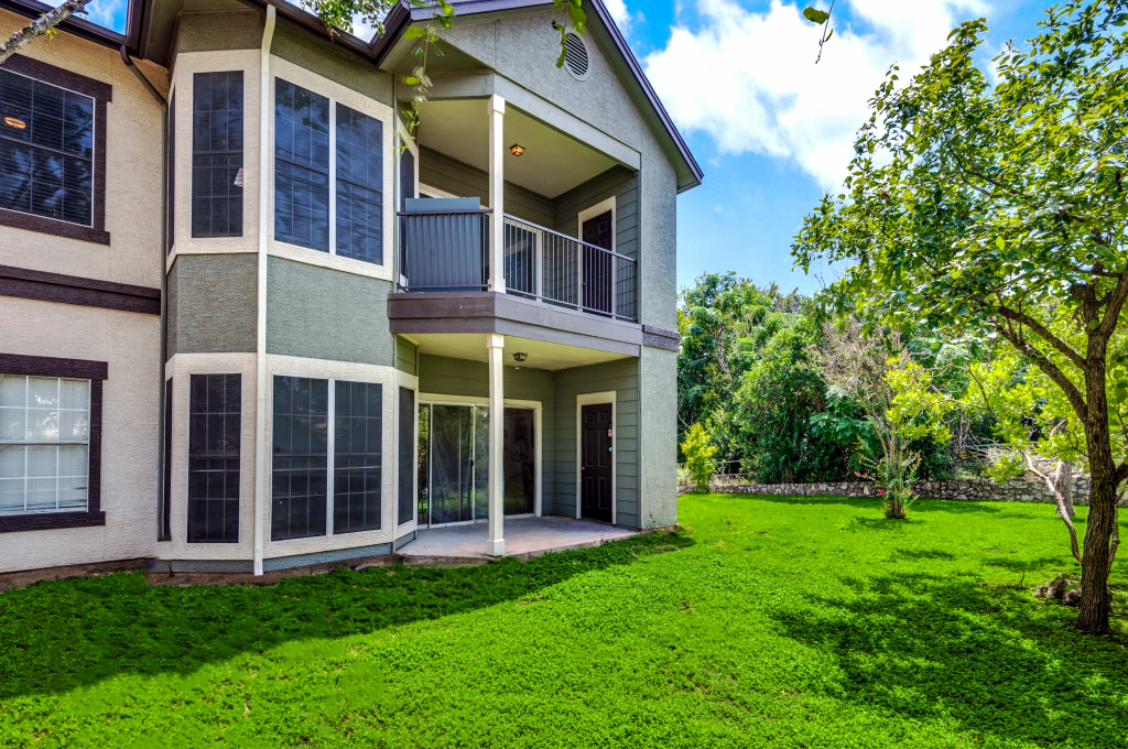 a large home with green grass and trees at The Stetson