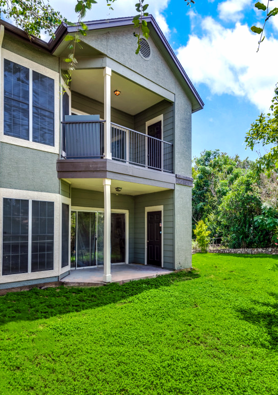 a large home with green grass and trees at The Stetson