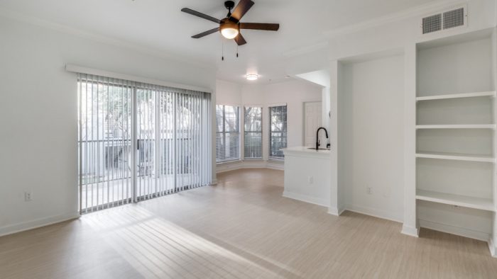 an empty room with a ceiling fan and sliding glass doors at The Stetson