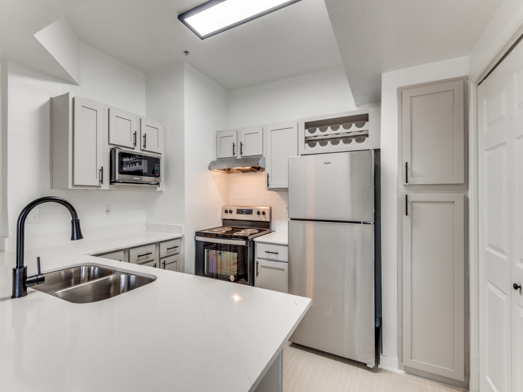 a kitchen with stainless steel appliances and white cabinets at The Stetson