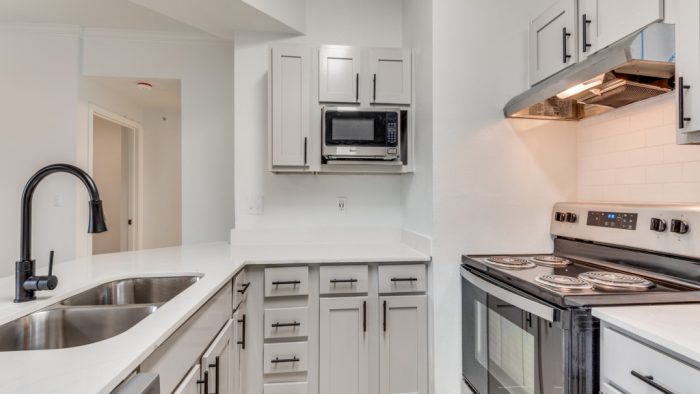 a kitchen with stainless steel appliances and white cabinets at The Stetson