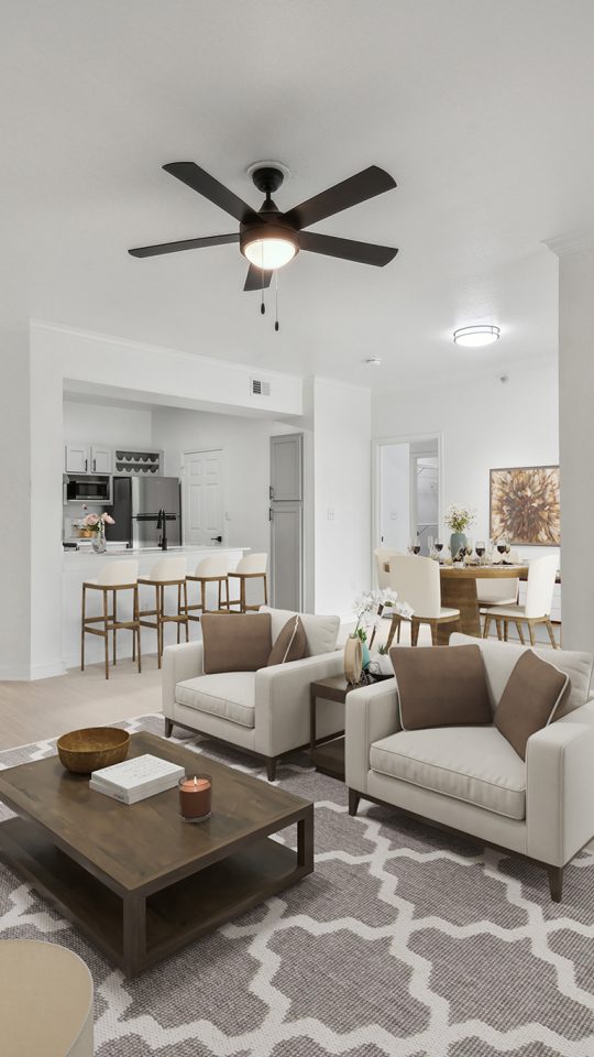 a living room with a ceiling fan and white walls at The Stetson