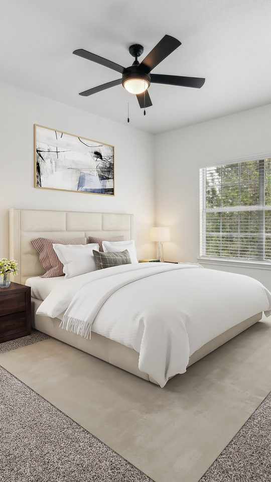 a bedroom with a ceiling fan and white walls at The Stetson